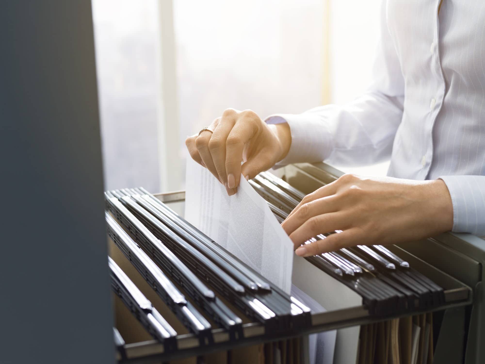 Home - office clerk searching files in the filing cabinet